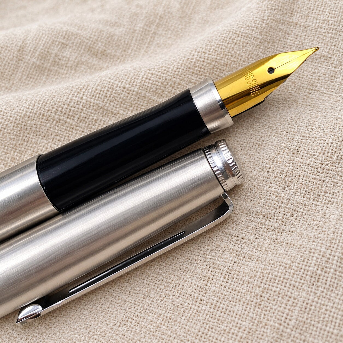 Stainless steel Wing Sung 500 fountain pen shown uncapped with its gold-tone nib