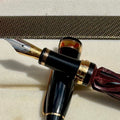 Hero Yundiao fountain pen nib and black grip beside the gold-trimmed cap