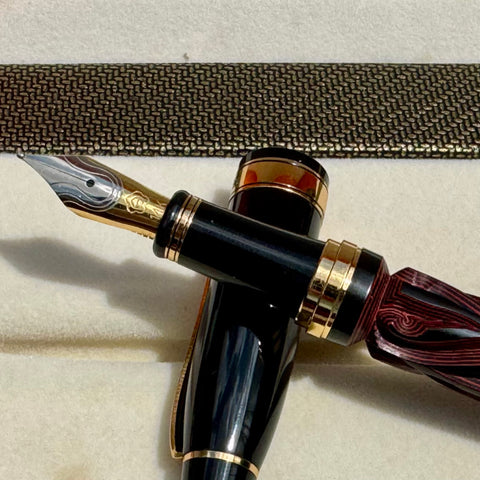 Hero Yundiao fountain pen nib and black grip beside the gold-trimmed cap