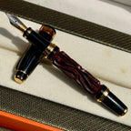 Uncapped Hero Yundiao fountain pen showing its carved red and black barrel and two-tone nib