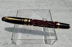 Hero Yundiao fountain pen with a carved red and black barrel, black cap, and gold-tone trim on a clear stand
