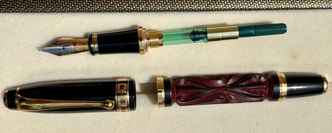 Hero Yundiao fountain pen disassembled to show the nib section, green converter, carved barrel, and cap