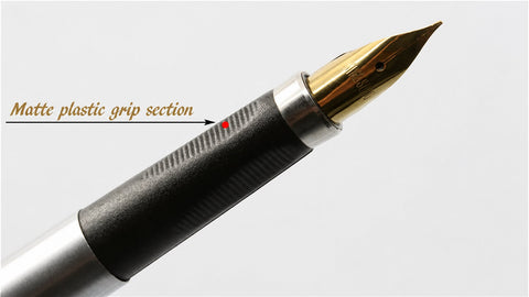 A close-up of a fountain pen nib and grip with a stainless steel body, showing a polished gold-tone nib with engraved brand name and a black grip, on a clean white background.